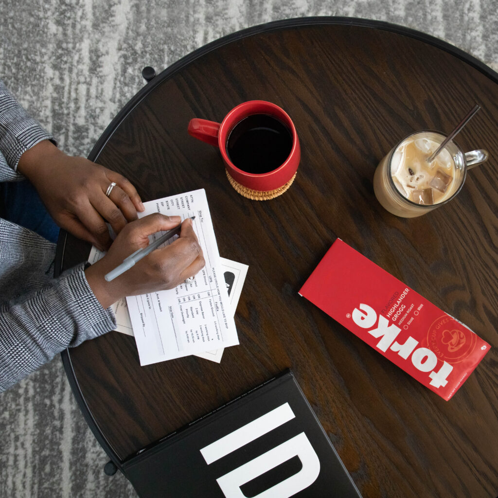 A woman filling out a card with Torke Coffee on the table